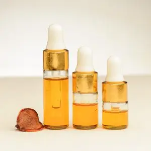 Drei Fläschchen mit 2 ml, 3 ml und 4 ml ätherischem Baldrianöl mit einer orangefarbenen Tönung