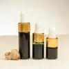 Drei Fläschchen mit ätherischem Seetangöl zu 2 ml, 3 ml und 4 ml neben einer Muschel