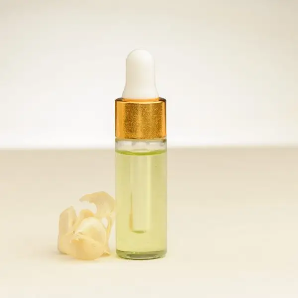 4 ml Fläschchen ätherisches Maiglöckchenöl neben einer Maiglöckchenblüte
